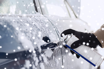 Image showing closeup of man hand with lock door de-icer