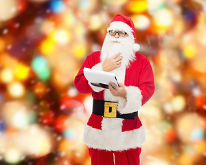 Image showing man in costume of santa claus with notepad