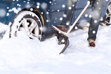 Image showing closeup of man digging snow with shovel near car