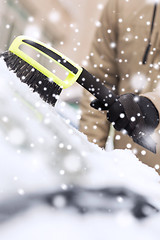 Image showing closeup of man cleaning snow from car