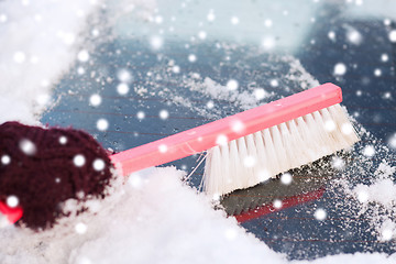 Image showing closeup of woman cleaning snow from car