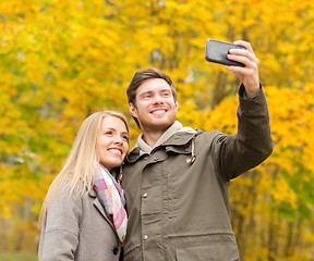 Image showing smiling couple hugging in autumn park