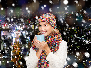 Image showing smiling young woman in winter clothes with cup