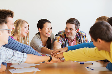 Image showing group of smiling students with hand on top