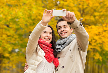 Image showing smiling couple hugging in autumn park