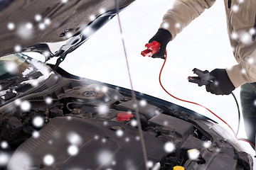 Image showing closeup of man under bonnet with starter cables