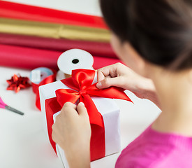 Image showing close up of woman decorating christmas presents