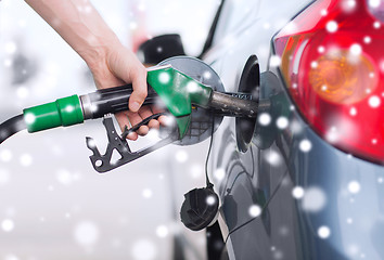 Image showing close up of male hand fuel nozzle in car tank