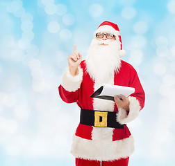 Image showing man in costume of santa claus with notepad