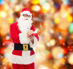 Image showing man in costume of santa claus with notepad