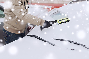 Image showing closeup of man cleaning snow from car