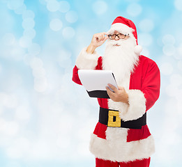 Image showing man in costume of santa claus with notepad