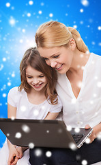 Image showing smiling mother and little girl with laptop