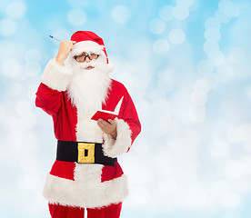 Image showing man in costume of santa claus with notepad