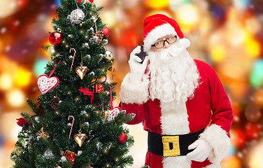 Image showing santa claus with smartphone and christmas tree