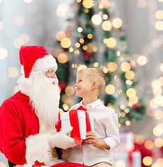 Image showing smiling little boy with santa claus and gifts