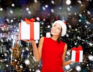 Image showing smiling woman in red dress with gift box