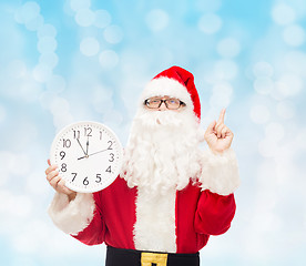 Image showing man in costume of santa claus with clock