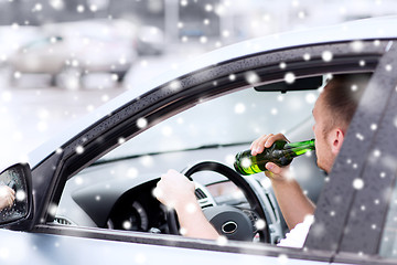 Image showing close up of man drinking alcohol while driving car