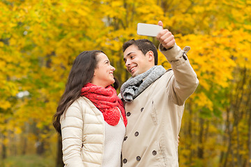 Image showing smiling couple hugging in autumn park