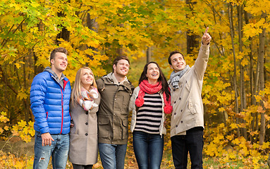 Image showing group of smiling men and women in autumn park