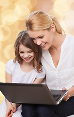 Image showing smiling mother and little girl with laptop