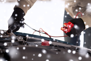 Image showing closeup of man under bonnet with starter cables