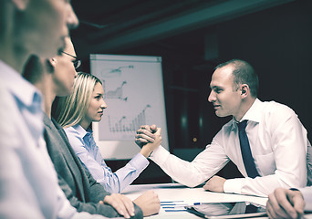 Image showing businesswoman and businessman arm wrestling