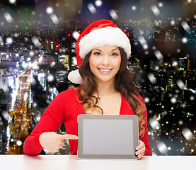 Image showing smiling woman in santa hat with gift and tablet pc