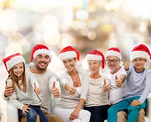 Image showing happy family in santa hats showing thumbs up