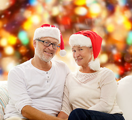 Image showing happy senior couple in santa helper hats