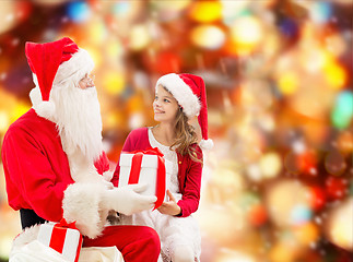 Image showing smiling little girl with santa claus and gifts