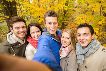 Image showing group of smiling men and women in autumn park