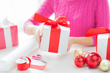 Image showing close up of woman decorating christmas presents