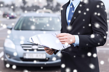 Image showing close up of man with clipboard and car documents