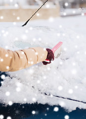 Image showing closeup of woman cleaning snow from car