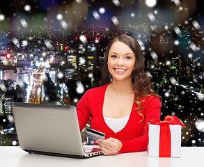 Image showing smiling woman with credit card and laptop