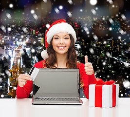 Image showing smiling woman with credit card and laptop