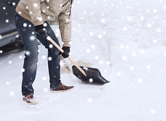 Image showing closeup of man digging snow with shovel near car