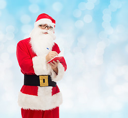 Image showing man in costume of santa claus with notepad