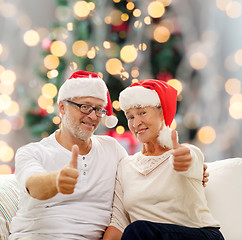 Image showing happy senior couple in santa helper hats