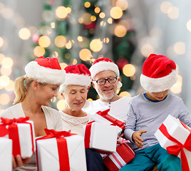 Image showing happy family in santa helper hats with gift boxes