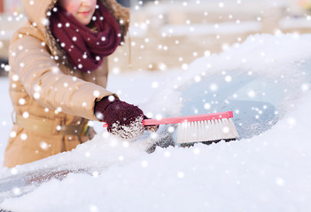 Image showing closeup of woman cleaning snow from car