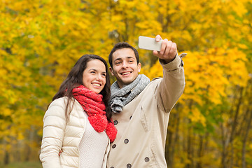 Image showing smiling couple hugging in autumn park