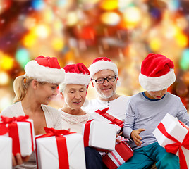 Image showing happy family in santa helper hats with gift boxes