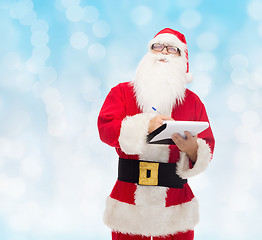 Image showing man in costume of santa claus with notepad