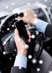 Image showing close up of man using smartphone while driving car