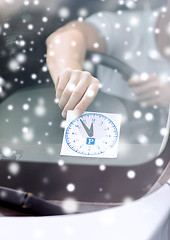 Image showing close up of man putting parking clock