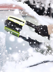 Image showing closeup of man cleaning snow from car