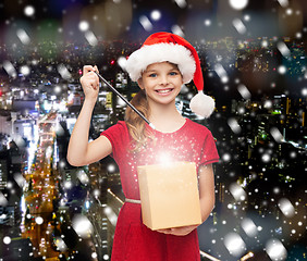 Image showing smiling girl in santa helper hat with gift box